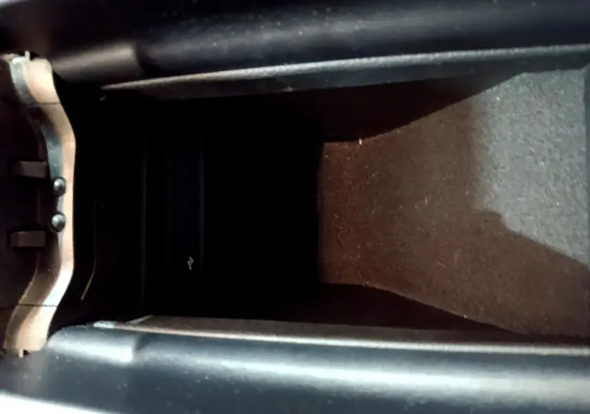 Vue rapprochée de la console centrale noire de la Mercedes Classe A 250 e Business Line 2020, avec compartiment de rangement.