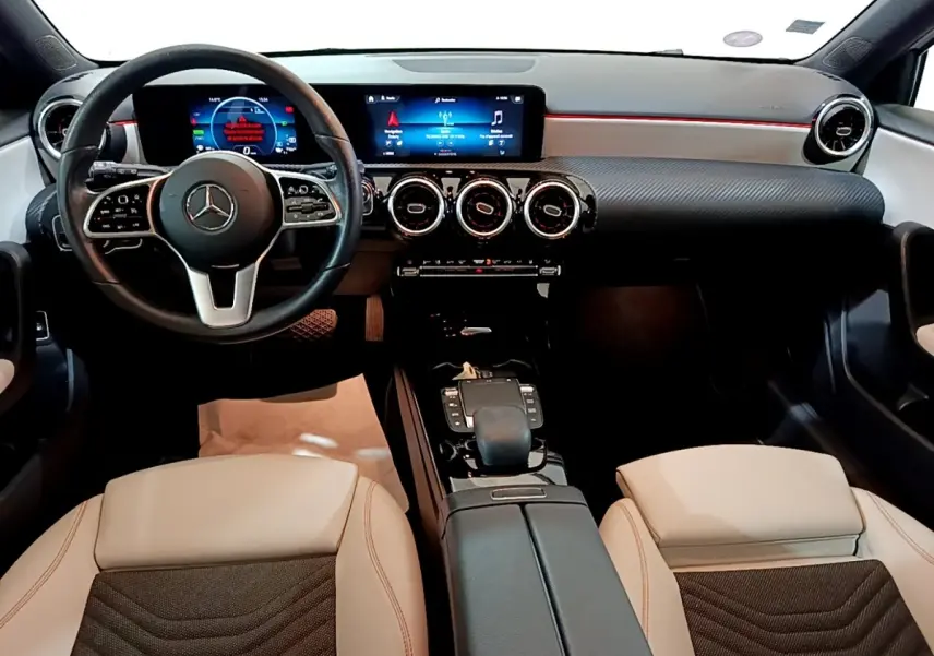 Vue intérieure avant de la Mercedes Classe A 250 e Business Line 2020, volant cuir noir et sièges beige avec console centrale noire.