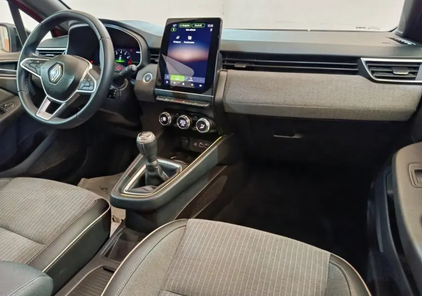 Vue intérieure avant de la Renault Clio Techno TCe 90 avec tableau de bord moderne et écran tactile vertical.