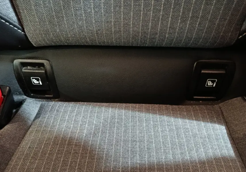 Détail des commandes Isofix sur la banquette arrière en tissu gris de la Renault Clio Techno TCe 90 2024.