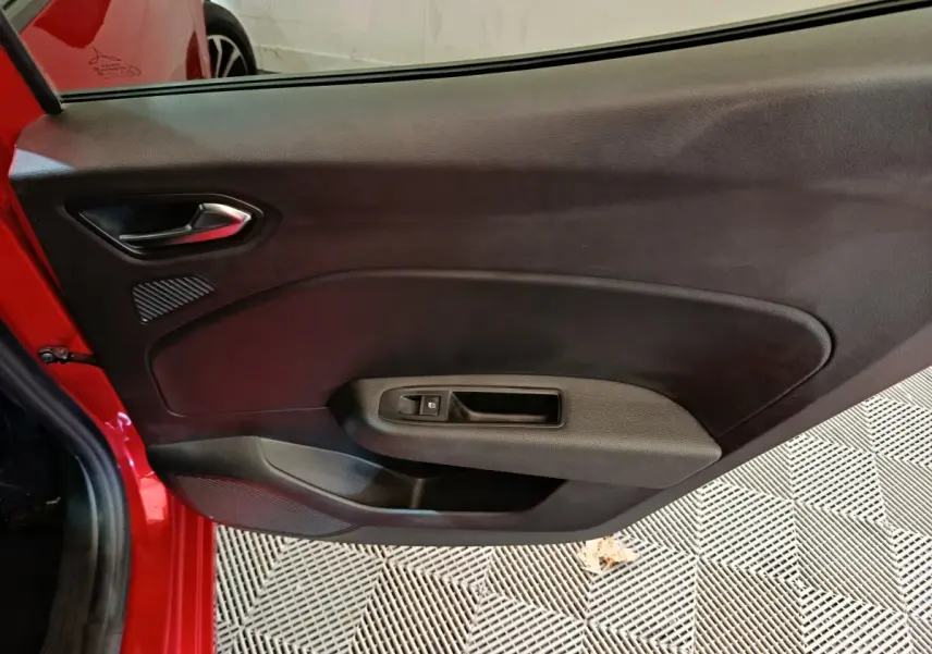 Vue intérieure de la porte arrière gauche rouge d'une Renault Clio 2024, avec poignée et commande de vitre noire.