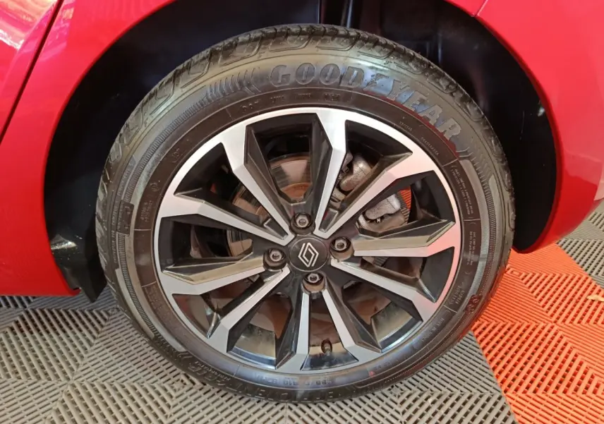 Gros plan sur la roue avant droite d’une Renault Clio rouge 2024 avec jante alliage noire et argentée au design moderne.