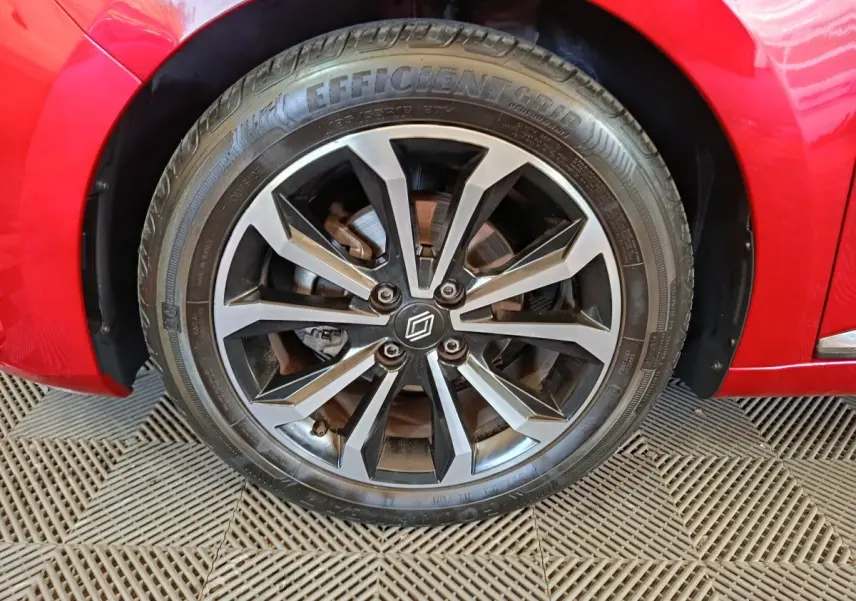 Gros plan sur la roue avant droite de la Renault Clio Techno TCe 90 rouge, avec jante alliage noire et argentée.