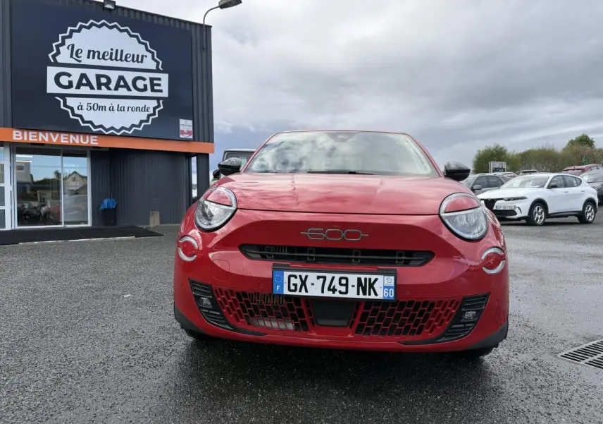 Vue frontale d'une FIAT 600 rouge 2024 avec logo chromé 600 sur la calandre et phares ronds distinctifs.