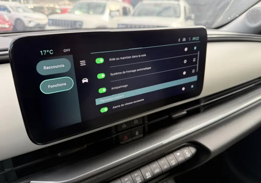 Écran tactile central affichant les aides à la conduite dans l'habitacle ivoire et noir d'une FIAT 600 rouge 2024.