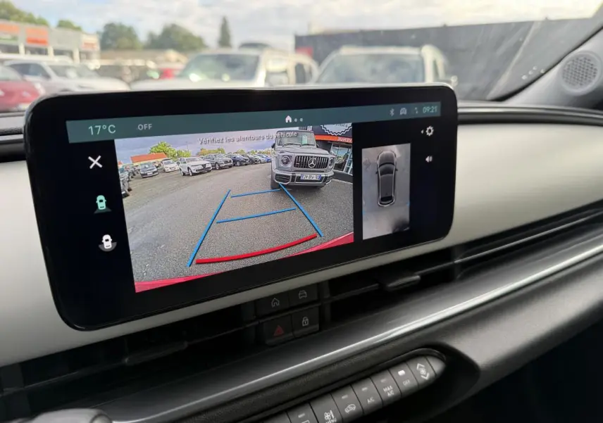 Vue intérieure du tableau de bord ivoire de la Fiat 600 La Prima 2024 avec écran affichant la caméra de recul en action.