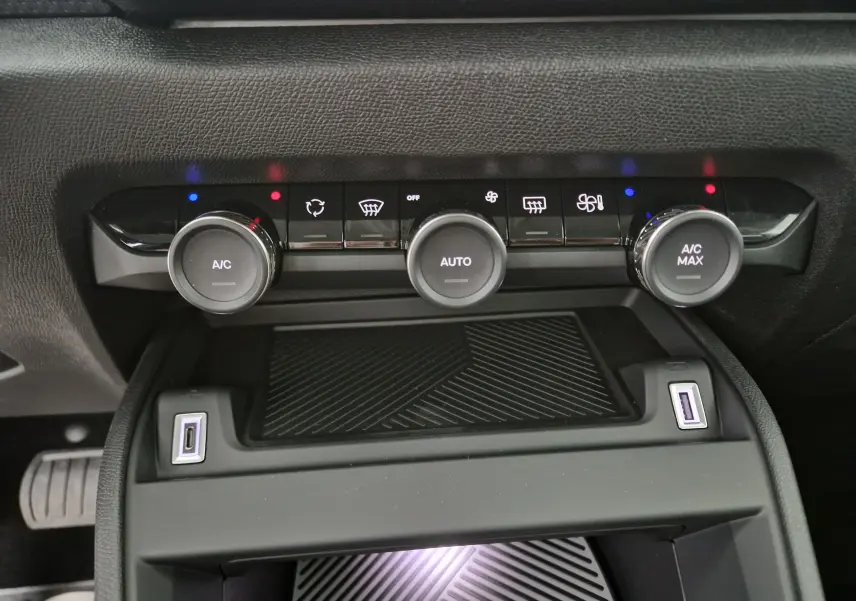 Détail de la console centrale noire du Citroën C4 2025 avec commandes climatisation et ports USB visibles.