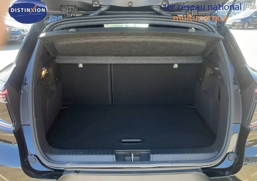 Coffre ouvert en vue arrière d'un Renault Captur 2025 noir étoile métal, montrant l'espace de chargement vide.