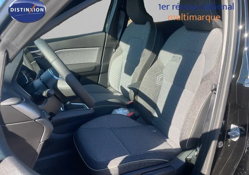 Intérieur du Renault Captur E-Tech hybride 2025 en noir étoile métal, vue côté gauche sur sièges tissu gris et volant.