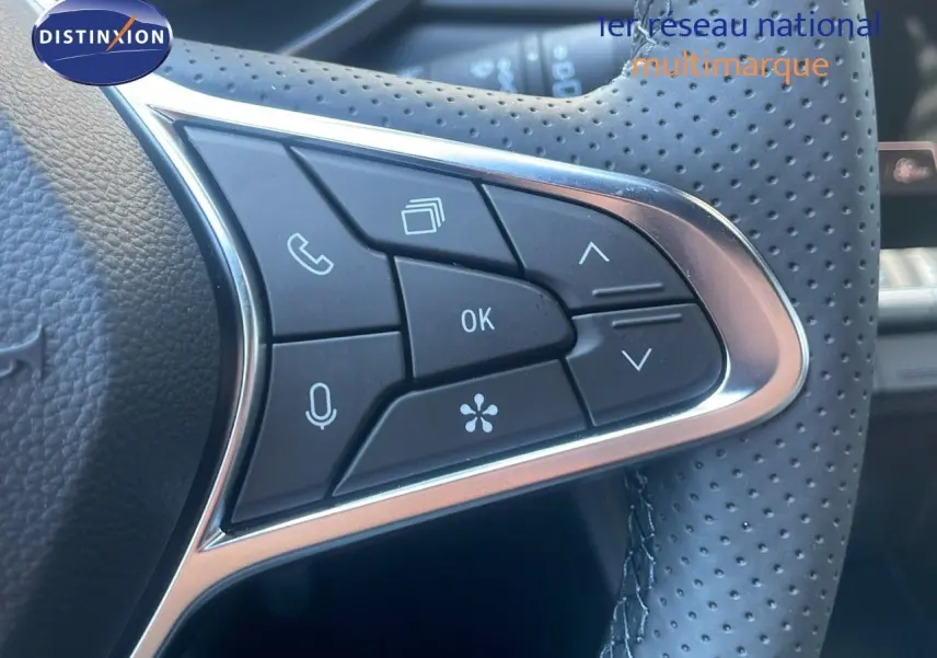 Gros plan sur les commandes du volant en cuir perforé du Renault Captur E-Tech hybride noir étoile métal 2025.