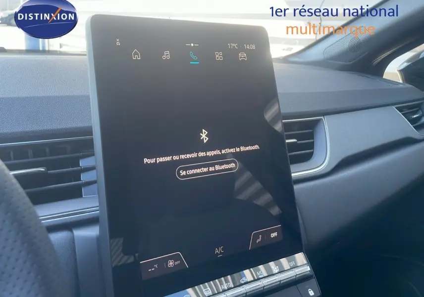 Écran tactile central allumé dans l'habitacle noir du Renault Captur E-Tech Hybrid 2025, vue côté passager.