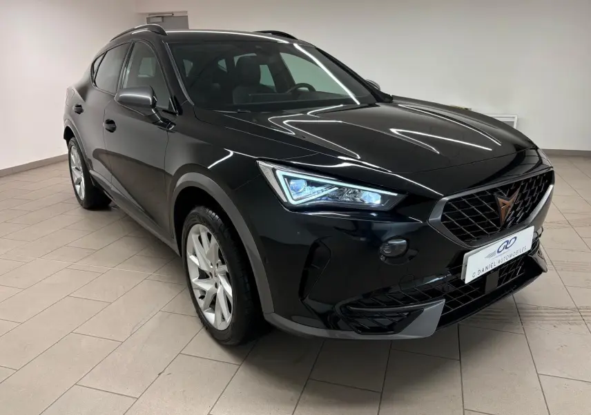 Vue 3/4 avant gauche du CUPRA Formentor 2024 noir minuit avec calandre distinctive et phares LED allumés.
