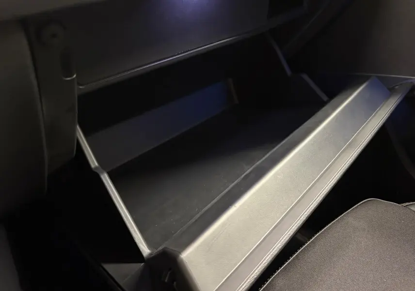 Gros plan sur la boîte à gants ouverte à droite dans l’habitacle noir du CUPRA Formentor 2024 Noir Minuit.