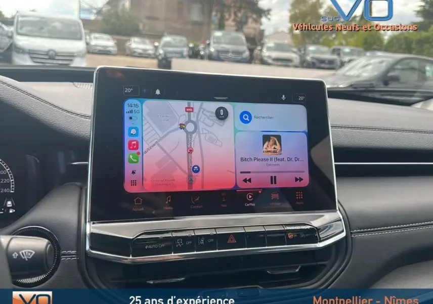 Vue rapprochée de l'écran tactile central du Jeep Compass 2023, affichant navigation et musique, intérieur noir.