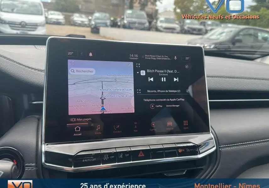 Écran tactile central du tableau de bord du Jeep Compass bleu 2023, affichant navigation et musique en stationnement.