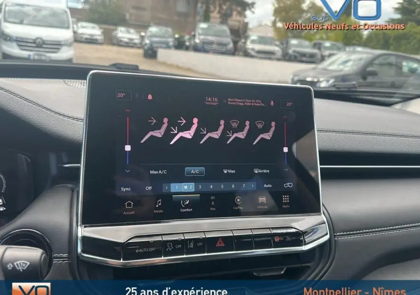 Vue rapprochée de l'écran tactile central du tableau de bord du Jeep Compass bleu 2023 avec commandes climatisation affichées.