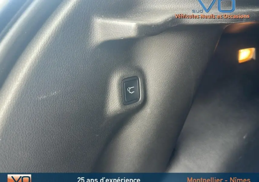 Bouton d'ouverture électrique du hayon dans le coffre d'un Jeep Compass bleu 2023, version Limited.