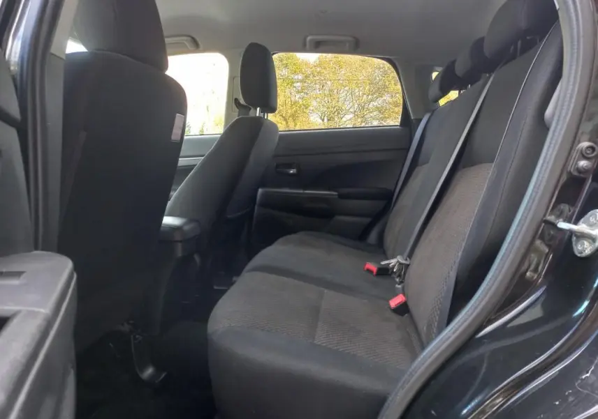 Vue intérieure côté droit montrant la banquette arrière noire du Mitsubishi ASX Invite 2WD 2020 avec ceinture de sécurité.