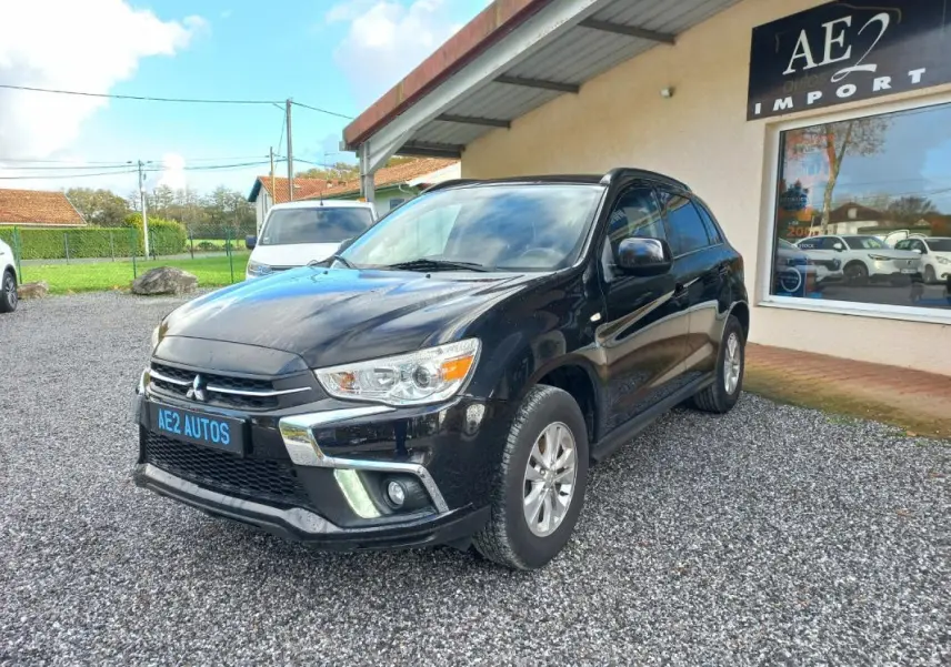 SUV Mitsubishi ASX noir vu en 3/4 avant droit, avec jantes 16 pouces et calandre chromée brillante.