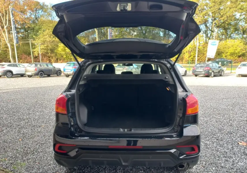 Vue arrière du Mitsubishi ASX noir 2020 avec coffre ouvert, feux arrière visibles et hayon levé en extérieur.