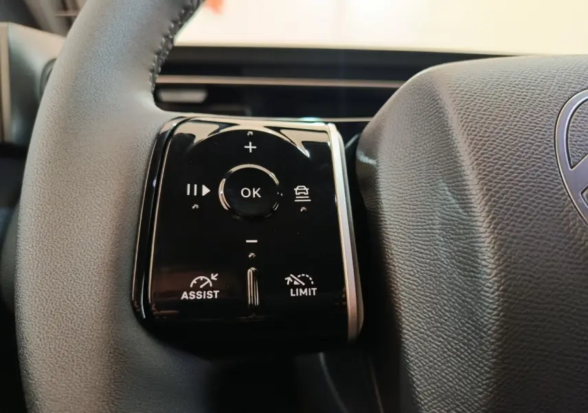 Gros plan sur les commandes noires du volant cuir du Citroën C5 Hybride 2026, côté gauche.