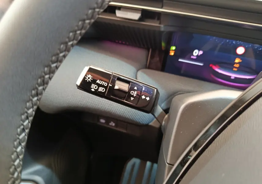 Gros plan sur la commande des feux à gauche du volant dans l’habitacle gris du Citroën C5 hybride 2026.