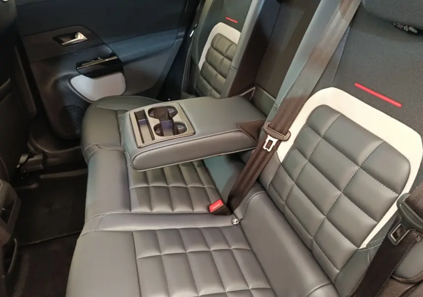 Vue intérieure côté droit des sièges arrière gris foncé avec accoudoir central et porte-gobelets du Citroën C5 Hybride 2026.