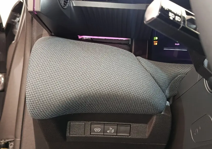 Détail de l'accoudoir central gris et des commandes sous le tableau de bord d'une Citroën C5 hybride 2026.