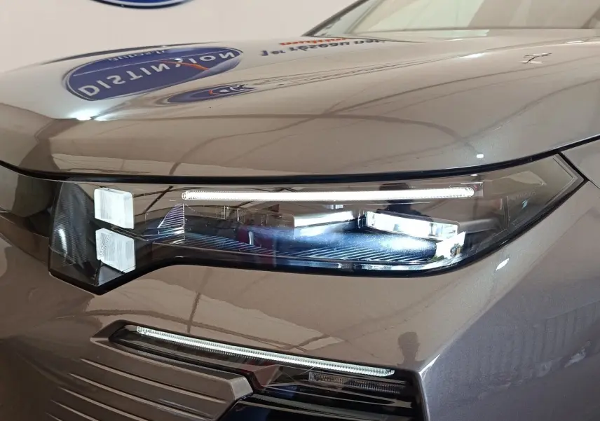 Gros plan sur le phare avant droit gris foncé du Citroën C5 Hybride 2026 avec éclairage LED distinctif.
