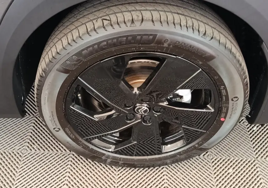 Gros plan sur la roue avant gauche de la Citroën C5 Hybride 2026 avec jante noire brillante et pneu Michelin.
