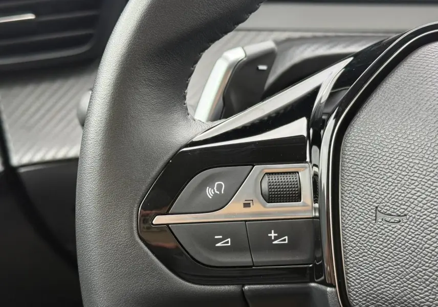 Gros plan sur les commandes audio au volant noir brillant du Peugeot 208 1.2 Hybrid 110ch Style 2025.