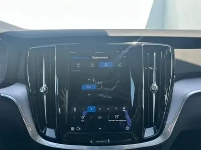 Gros plan sur l'écran tactile central noir brillant du tableau de bord du Volvo S60 Thunder Grey 2024.