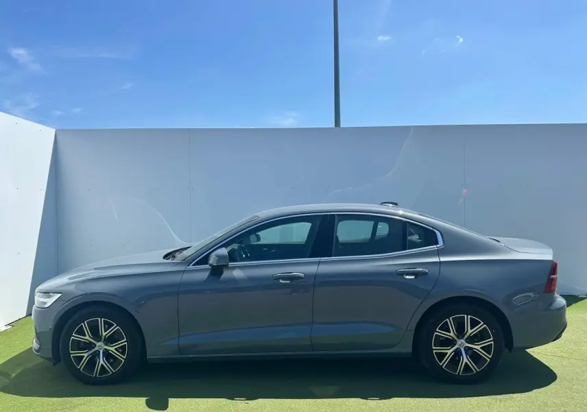 Profil latéral droit d'une Volvo S60 2024 Thunder Grey Metal avec jantes alliage 17 pouces en Y noir et diamant.