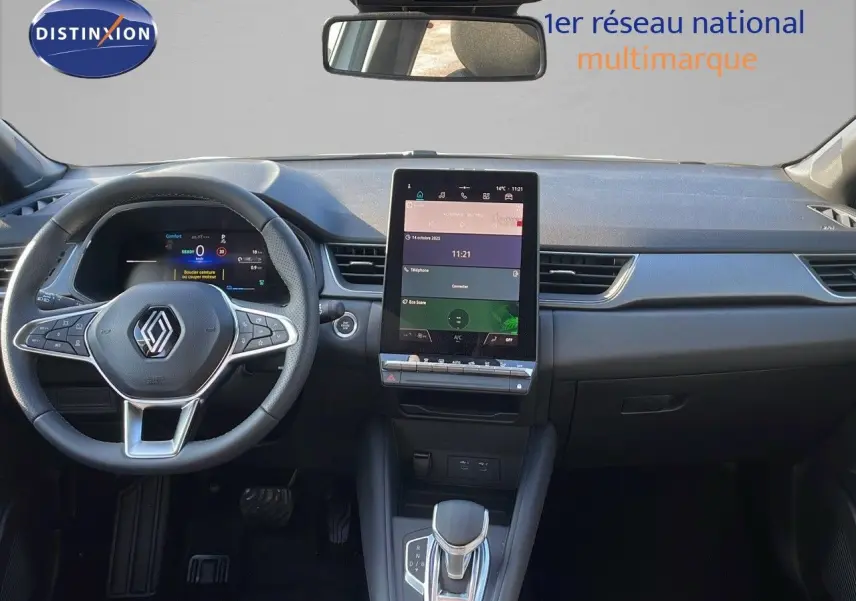Vue intérieure frontale du tableau de bord du Renault Captur blanc nacré avec écran tactile vertical et volant multifonction.