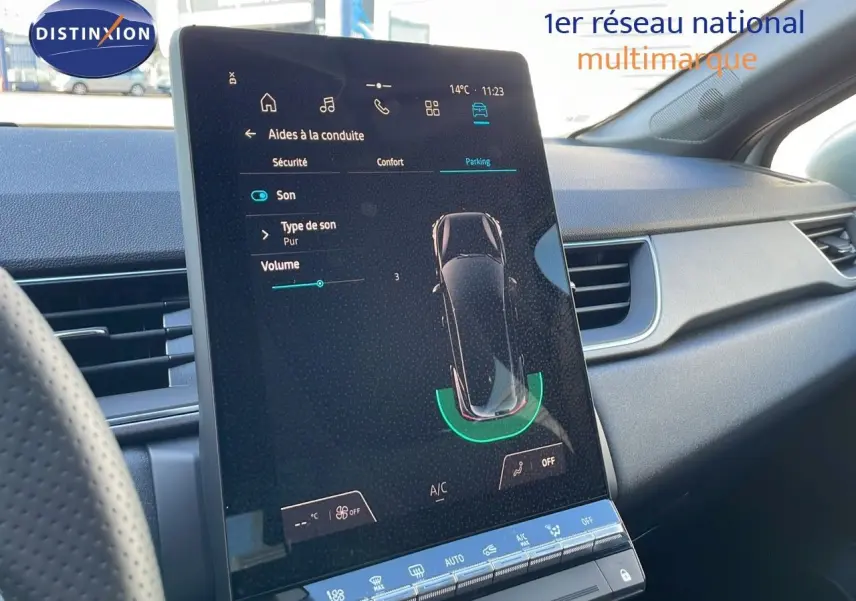 Vue intérieure du tableau de bord du Renault Captur blanc nacré avec écran tactile central affichant les aides à la conduite.