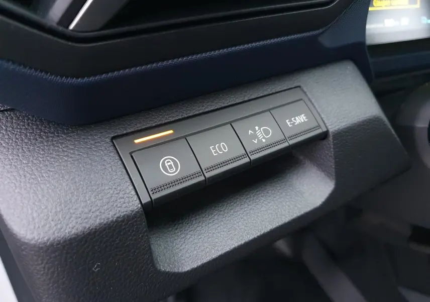 Gros plan sur les boutons de mode de conduite du tableau de bord du Dacia Duster 1.6 Hybrid blanc glacier.