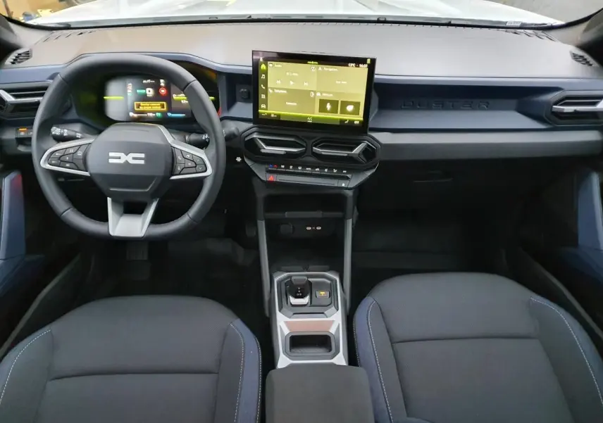 Vue intérieure avant du tableau de bord noir du Dacia Duster 1.6 Hybrid 140 avec écran tactile central et volant multifonction.