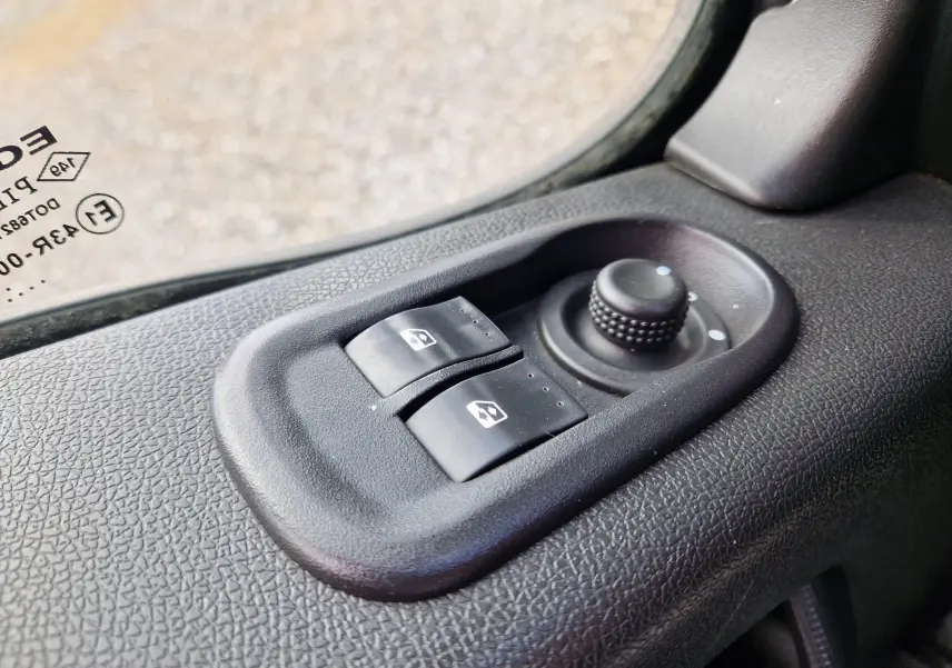 Gros plan sur les commandes électriques des vitres et le réglage des rétroviseurs côté conducteur du Renault Master blanc 2019.