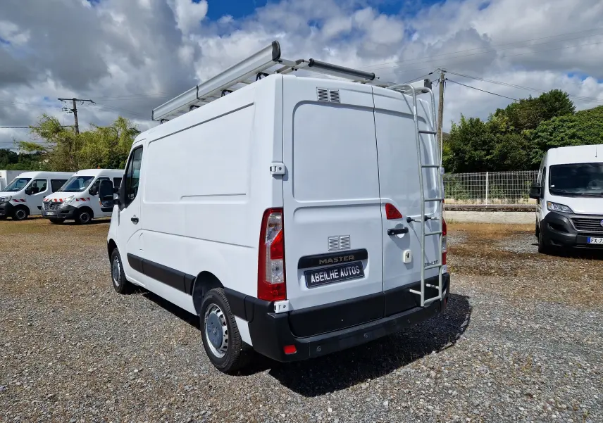 Vue 3/4 arrière droite d’un utilitaire blanc Renault Master 2019 avec galerie et échelle sur porte arrière.
