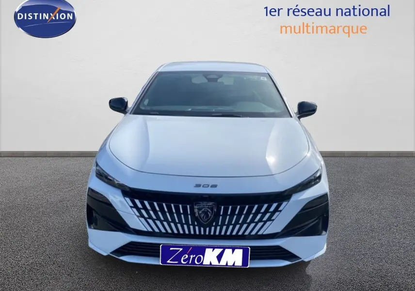 Vue de face d'une Peugeot 308 Hybrid 145ch GT blanche Okenite Metal avec calandre noire distinctive et logo lion central.
