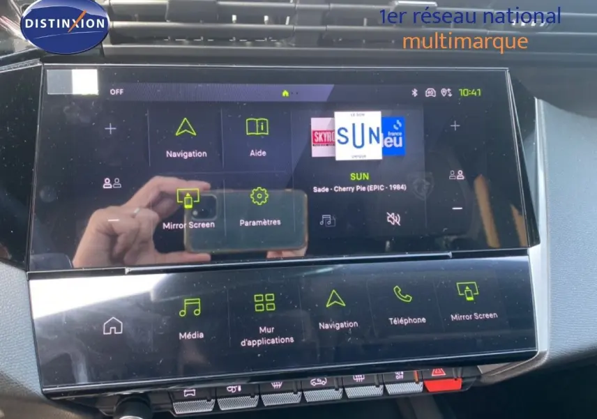 Vue rapprochée de l'écran tactile central de la Peugeot 308 Hybrid blanc Okenite, affichant le menu multimédia et navigation.