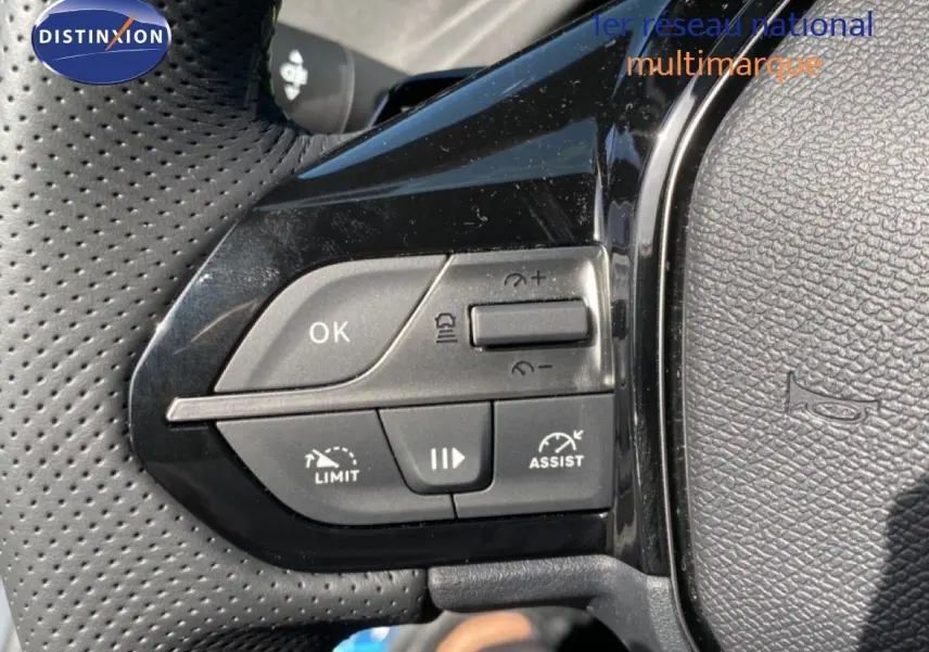 Gros plan sur les commandes de régulateur de vitesse au volant perforé d’une Peugeot 308 Hybrid 2026.