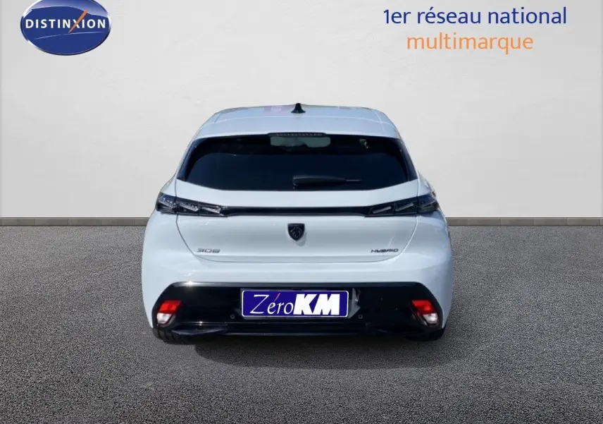 Vue arrière d'une Peugeot 308 Hybrid blanche Okenite Metal avec feux arrière fins et plaque Zero KM.