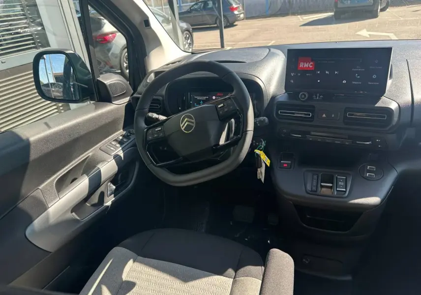 Vue intérieure côté conducteur du Citroën Berlingo 2026, tableau de bord noir avec écran tactile et volant multifonction.