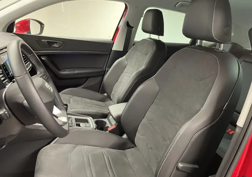 Intérieur côté conducteur du SEAT Ateca Rouge Velvet 2024, sièges en cuir et alcantara avec surpiqûres blanches visibles.