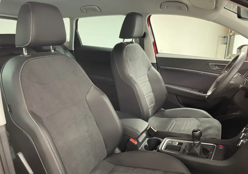 Vue intérieure côté conducteur du SEAT Ateca 2024 avec sièges noirs en cuir et alcantara, boîte manuelle visible.