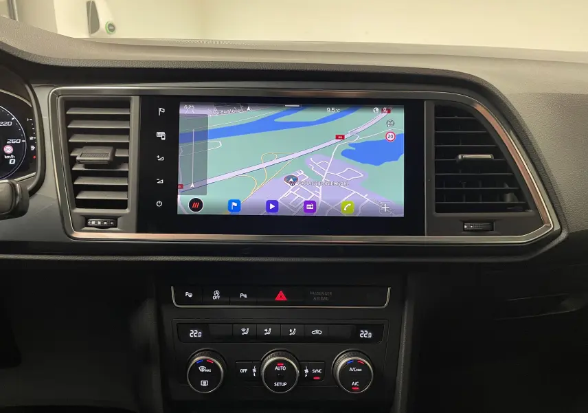 Vue intérieure du tableau de bord du SEAT Ateca 2024 avec écran tactile de navigation et commandes de climatisation.