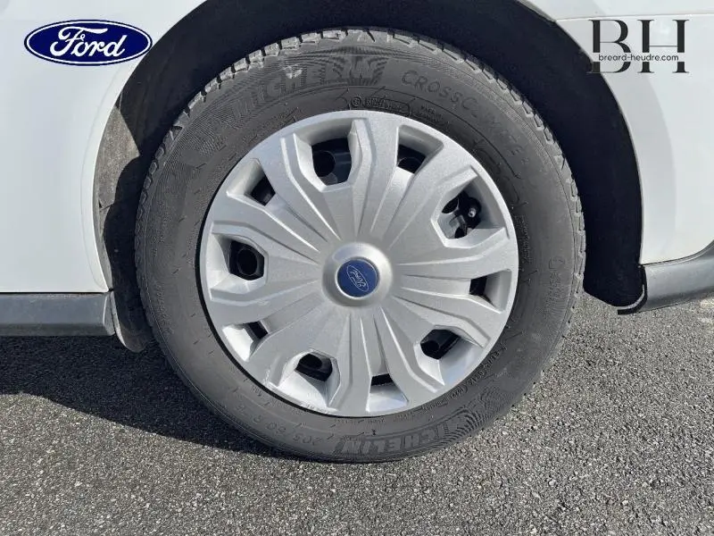 Gros plan sur la roue avant gauche blanche glacier du Ford Transit Connect avec enjoliveur gris et pneu Michelin.