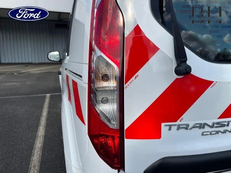 Gros plan sur l'arrière droit blanc glacier du Ford Transit Connect avec bandes rouges de signalisation réfléchissantes.
