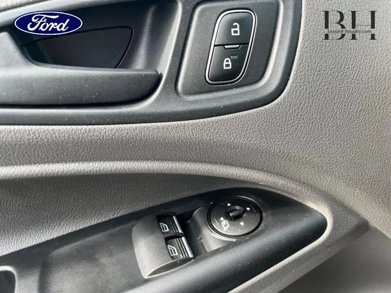 Détail de la porte intérieure côté conducteur du Ford Transit Connect blanc glacier, avec commandes de vitres et verrouillage.